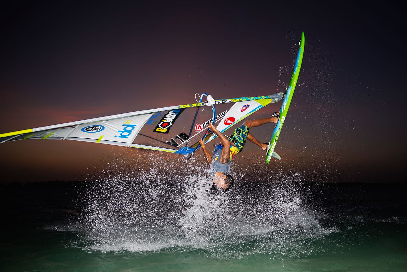 Gollito Estredo dando una vuelta en el aire con su tabla de windsurf al atardecer